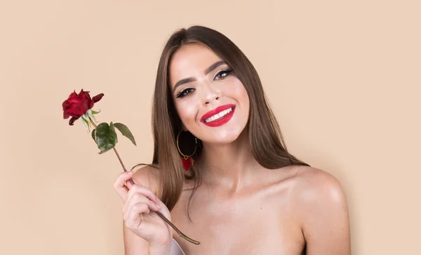 Krásná romantická usmívající se žena s červenými růžovými květy. Nádherný luxusní make-up. Valentýnský design. Portrét modelky dívky na pozadí studia. Krásná módní dívka, portrét hlavy. — Stock fotografie