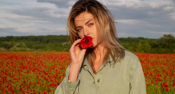 Beautiful young woman in poppy field. Woman on the poppies meadow. Beautiful girl on a poppy field outdoor. Poppies flowers. — Stock Photo, Image