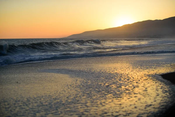 Paesaggio di mare e spiaggia tropicale al tramonto o all'alba per viaggi di piacere e vacanze. Riflessione del sole in acqua e sabbia sulla spiaggia. — Foto Stock