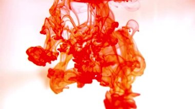 Bir tutam boya. Soyut arkaplan. Boya suya sıçrar ve yavaşça çözünür. Renkli boya damlaları suya karışıyor..