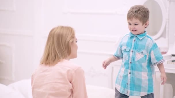 Moeder en kind zoon spelen in bed. Moeder en kind aan het praten in de slaapkamer. — Stockvideo