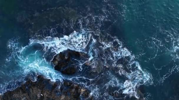 Vista aérea de olas y acantilados. Ondas oceánicas rompiendo rocas. Peligro mar ola estrellándose en la costa de roca con spray y espuma. — Vídeo de stock