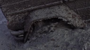 Çamurda tekerlekler. Kirli Araba kötü yolda. Tekerleği yavaş çekimde yakın çekim.