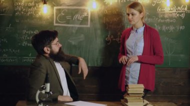 Öğretmen açıklama matematiği. Üniversitede tahtada düşünen bir kız öğrenci. Bir sınıfta ders veren bir profesör, eğitim konsepti. Matematik dersi. Matematik bilimi.