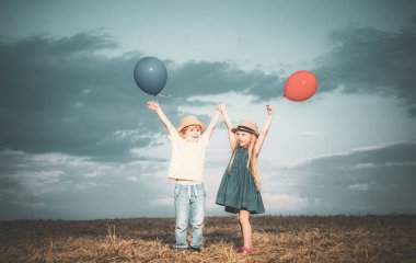 Yazın oynayan mutlu çocuklar. Küçük oğlan ve kız hayatın ve doğanın tadını çıkarıyorlar. Küçük kız ve oğlan yürümekten hoşlanırlar. Sahadaki mutlu kız ve oğlan. Pozitif küçük kız ve oğlan.