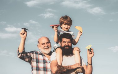 Boş zaman aktivitesi. Büyükbaba oyun zamanı. Mutlu gülümseyen çocuk, baba kameraya bakıyor. Jenerasyon konsepti. Erkek çoklu nesil portresi.