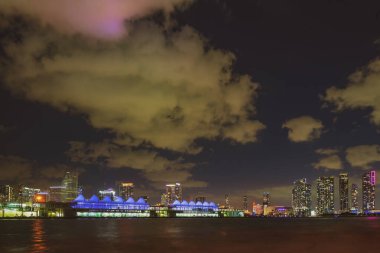 Miami, Florida, Biscayne Körfezi 'ndeki ABD silueti, şehir geceleri. Miami şehrinin gökdelenleri ve deniz üzerinde yansıması olan gökdelenleri..