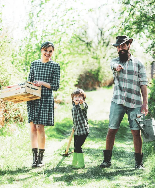 Happy family: mother, father, children son on spring garden background. Family gardening in the backyard garden. Happy family having fun at countryside. Happy family in vegetable garden. Earth day. — Stock Photo, Image