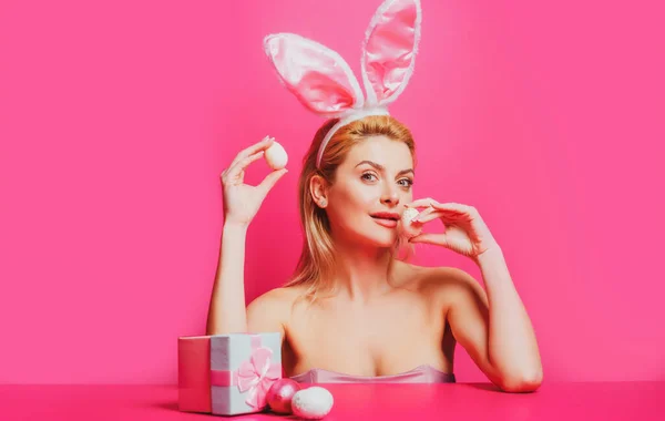 Mujer conejo sexy con huevos, aislado en la bandera rosa, espacio de copia. —  Fotos de Stock
