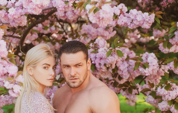 Junges Paar auf dem Hintergrund der Frühlingsblüte. Liebhaber mit romantischen Momenten. — Stockfoto