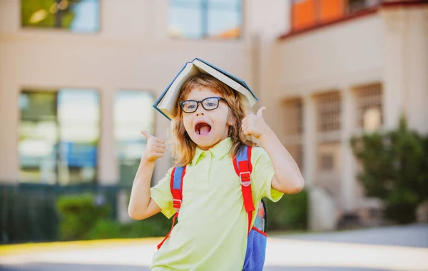 Glücklich lächelndes Kind mit Brille geht zum ersten Mal zur Schule. Schüler gehen studieren. Junge mit Tasche gehen in die Grundschule. Kind der Grundschule. Zurück zur Schule. Bildungskonzept für Kinder. — Stockfoto