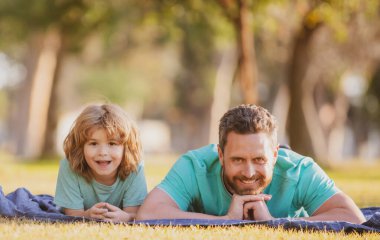 Mutlu baba ve oğul güneşli bir parkta tatilin tadını çıkarıyorlar..