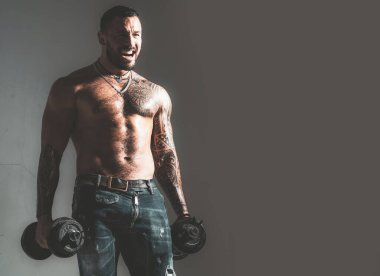 Dumbbell 'ın yanındaki adam. Vücut geliştiren kas geliştiren adam egzersiz yapıyor. Çıplak gövdeli kaslı seksi adam dambılla poz veriyor. Fitness konsepti. Erkek iri kıyım..