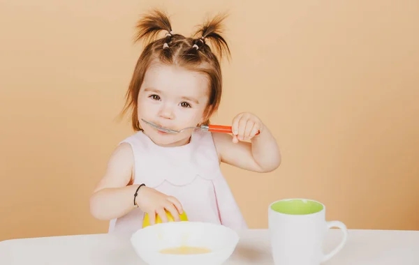 Baby 's eten, gezond voedsel voor een baby. Kleine baby die fruitpuree eet. — Stockfoto