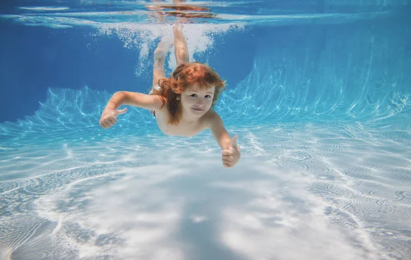 Menino subaquático nada debaixo d 'água na piscina. — Fotografia de Stock