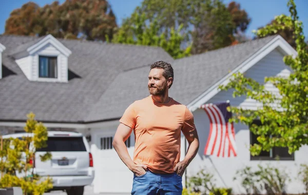 Man står utanför ett nytt amerikanskt hem. Snygg självsäker affärsman i t shirt, tittar upp. — Stockfoto