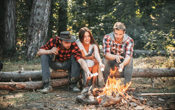 Οι φίλοι ψήνουν ζαχαρωτά στην φωτιά στο δάσος. Φίλοι για πικνίκ. Τουριστική ιδέα. Ψήνω ζαχαρωτά μπάρμπεκιου. Camp περιπέτεια και ταξιδιωτική έννοια. — Φωτογραφία Αρχείου