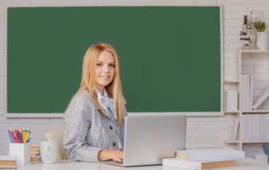 Sınıfta tahtadan arkaplanı olan genç, sarışın bir üniversite öğrencisinin portresi..