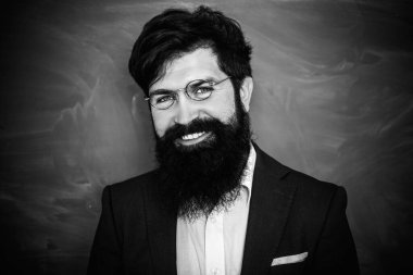 Öğretmenler zorluklar ve ilham. Okulda ki sakallı profesör sınıftaki masalarda. Okul sınıfında tebeşir tahtası yakınında genç sakallı öğretmen.