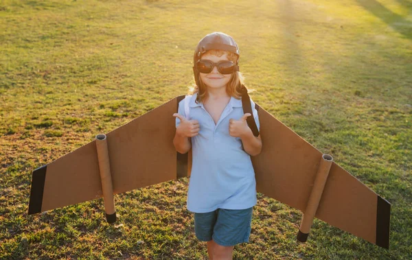 Barnpojken leker med flygplansvingar. Dröm om att bli pilot. Superhjälten flyger. Pojken drömmer om att flyga. bekymmersfritt barn leker utomhus. — Stockfoto