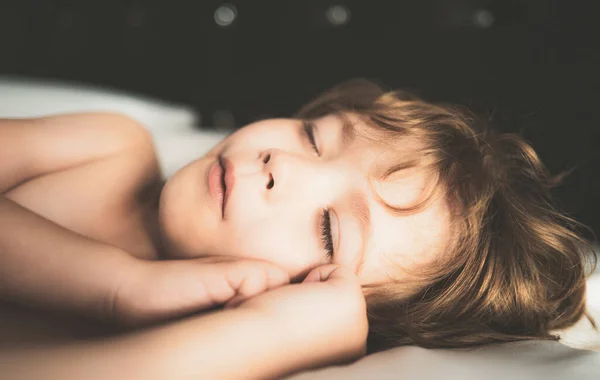 Παιδιά με πιτζάμες κοιμούνται στο κρεβάτι σε λευκό φόντο. Ώρα για ύπνο. — Φωτογραφία Αρχείου
