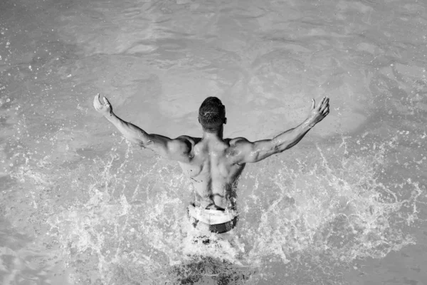 Férias de verão e viagens ao oceano. Fundo de água do oceano - animado. Homem desportivo em roupa de banho em água azul. Homem sexy em melhores praias do mundo. Viagens. — Fotografia de Stock