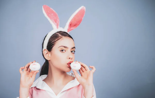 Mujer de Pascua. Los labios y la Pascua, lápiz labial beso huella en huevo de Pascua. Feliz Pascua. Mujer joven con orejas de conejo. Retrato de una mujer feliz con orejas de conejo. Caza de huevos. — Foto de Stock