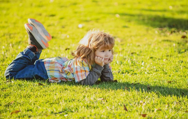 Bambino all'aperto nel parco. Ragazzo primaverile sdraiato sull'erba. Passeggiata estiva. Adattamento dei bambini. — Foto Stock