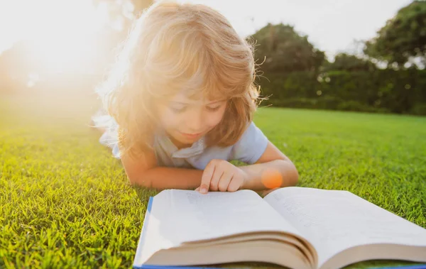 Lindo niño con libros al aire libre. Campamento de verano. Concepto de aprendizaje y educación para niños. — Foto de Stock