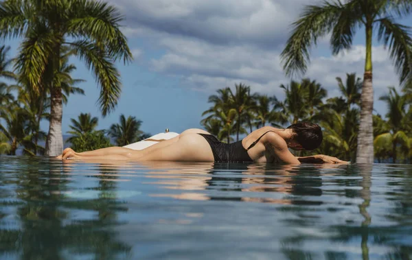セクシー女性日光浴でインフィニティプールで豪華なリゾート. — ストック写真