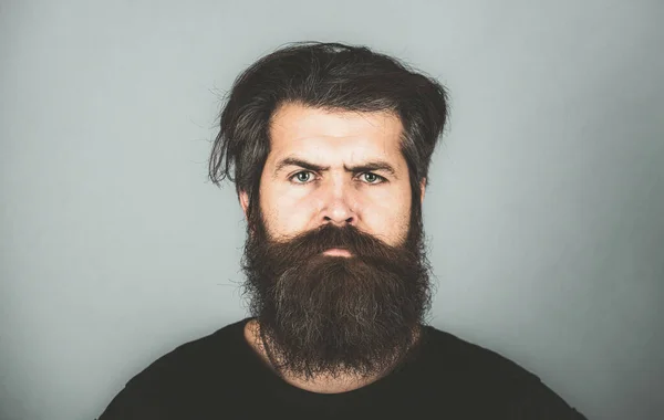 Retrato de homem sério confiante tem barba e bigode, olha a sério, isolado. Hipster com barba comprida e bigode. Homem barbudo. Bonito modelo masculino, close-up rosto. — Fotografia de Stock