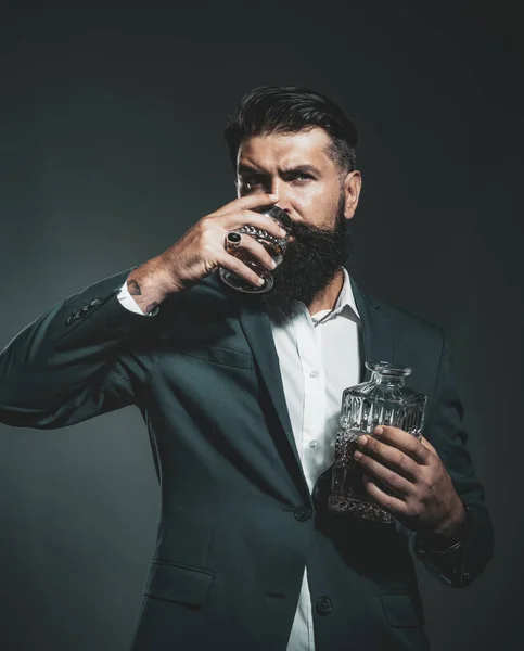 Mode-Stil-Konzept. Mann Barkeeper mit Bart hält Glasschnaps. Sommelier probiert teures Alkoholgetränk. Alkoholisches Getränk. — Stockfoto