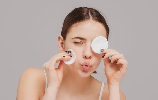 Beautiful funny woman with cotton pads, sponge, cotton ball. Skin care and beauty concept. Girl fun removes makeup with cotton ball from face. Skin care concept. Woman using cotton pad. — Stock Photo, Image