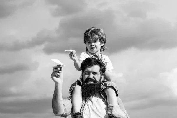 아버지와 아들. 아버지는 공원에서 아들을 타고 다시 타고. 공원에서 아버지와 아들. 꿈의 자유 - 종이 비행기로 노는 즐거운 소년. — 스톡 사진