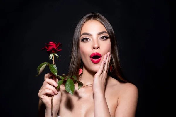 Здивована жінка з червоними губами і трояндовою квіткою. Портрет модної краси на студійному фоні . — стокове фото