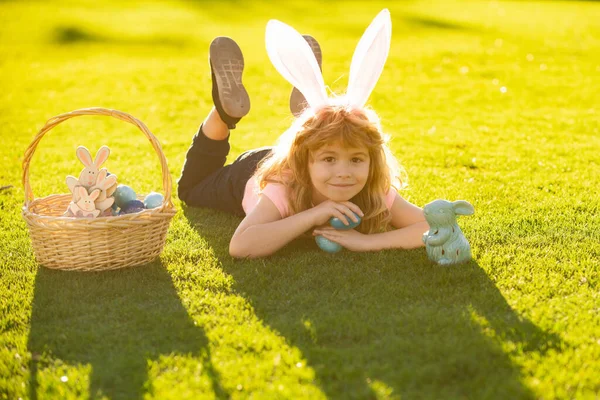 Vrolijk Pasen. Jongetje met paaseieren en konijnenoren buiten. Schattig kind met gelukkig Pasen in park. — Stockfoto