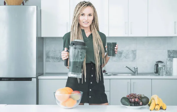 Mujer mantenga licuadora con batido verde. Estilo de vida saludable. Chica rubia sana bebe batido verde. Vegetariano vegetariano concepto vegetal. Mezcla de cóctel en la licuadora . — Foto de Stock