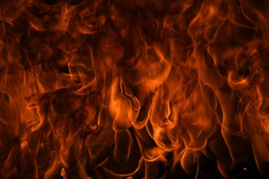 Siyah arka planda yangın alevleri. Ateş, izole edilmiş, soyut bir yapı. Yanan ateşle yanan patlama efekti.