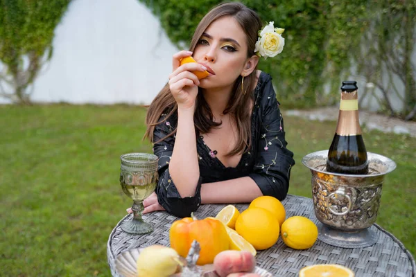 Retrato de verano de una hermosa mujer de moda comiendo naranja, frutas sexy de verano al aire libre. —  Fotos de Stock