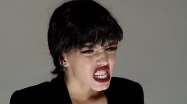 Bağıran ağız, bağıran duygusal genç kadın. Kızgın ve üzgün öfke çığlıkları. Gri stüdyo arka planında bağıran duygusal sinirli kadın. Duygusal, genç yüz.