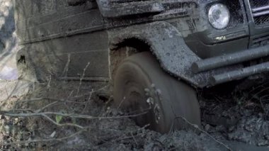 Tekerlek lastiği çamur ve pislikle dolu. Ağır çekim. Çamur ve su off-road yarışında sıçrıyor.