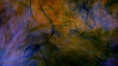 Bir tutam boya. Renk sıvısı. Soyut arkaplan. Boya suya sıçrar ve yavaşça çözünür. Renkli boya damlaları suya karışıyor..