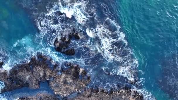 Luchtfoto van golven die de rots raken in zee. Bovenaanzicht van golven en kliffen. Zicht vanuit de lucht op golven en enkele rotsen. — Stockvideo