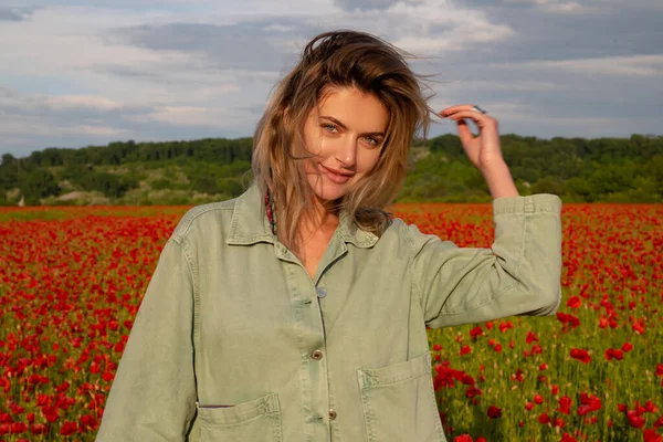 Portrait of beautiful woman are wearing casual clothes in field of poppy flowers. Girl on spring poppy field. Beautiful young woman in poppy field. — Stock Photo, Image