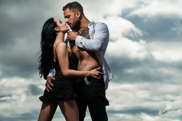 Sevgi dolu insanlar, birbirine aşık sevimli bir çift. Seksi kız ve çıplak gövdeli kaslı erkek arkadaşı açık havada öpüşüyor..