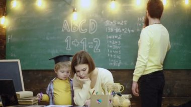 İlkokuldaki liseli çocuklar. Mutlu aile çizim kitabı. Anne baba ve oğul kitap ev ödevini okuyorlar. Anne ve babalar, çocuk sahibi olmaktan gurur duyuyor..