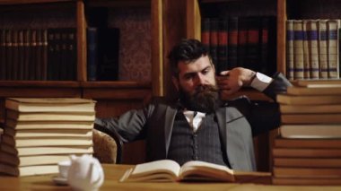 Eski kütüphanede saygıdeğer bir genç adam. Klasik klasik iç mimari. Klasik takım elbiseli iş adamı kitap okudu. Eski moda iş adamları.