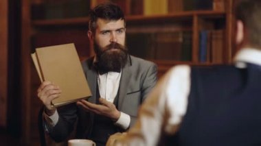 Profesör ve öğrenci kütüphanede tartışıyorlar. Bilim adamları konuşuyor. İnsan zekası kitaplığın yanında konuşuyor..