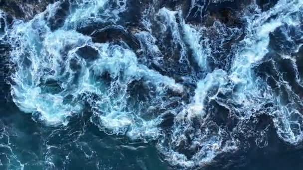 Golvende kust, oceaangolven die over rotsen breken. Water spat met schuim op de golven. — Stockvideo