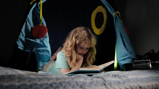 Een jongen die boeken leest. Gelukkige kindertijd, dromend kind lees verhaaltjes voor het slapen gaan, sprookje of sprookje. — Stockvideo